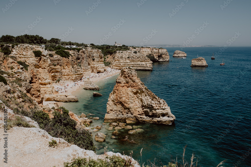 Natural arches of Praia da Marinha in Algarve, Portugal, Europe. Sunbeams over Marinha Beach one of the 100 most beautiful beaches in the world. Famous place for summer holidays