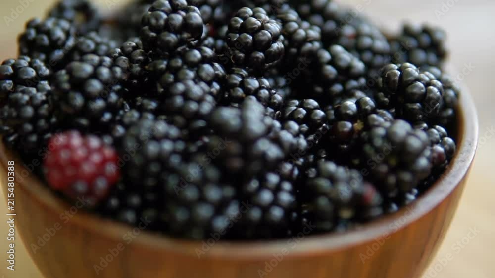 blackberries in bowl rotate on wooden table blackberries in bowl rotate on wooden table
