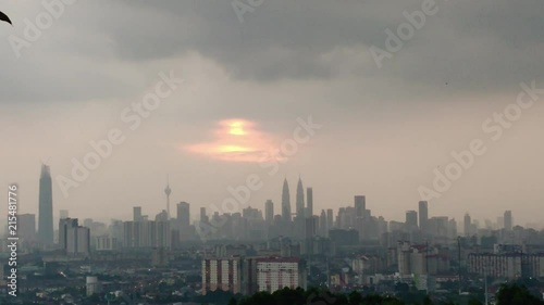 A view of the Kuala Lampur skyline at sunset. Beautiful colorful sky and light rays shining through clouds. photo