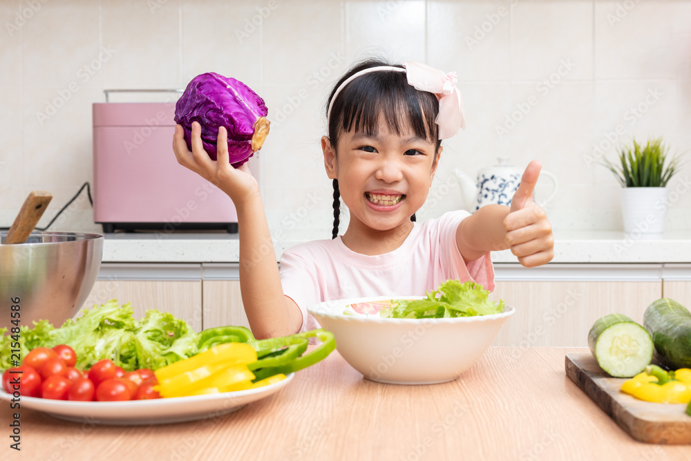 Asian Chinese little girl making salad in the kitchen Asian Chinese little girl making salad in the kitchen