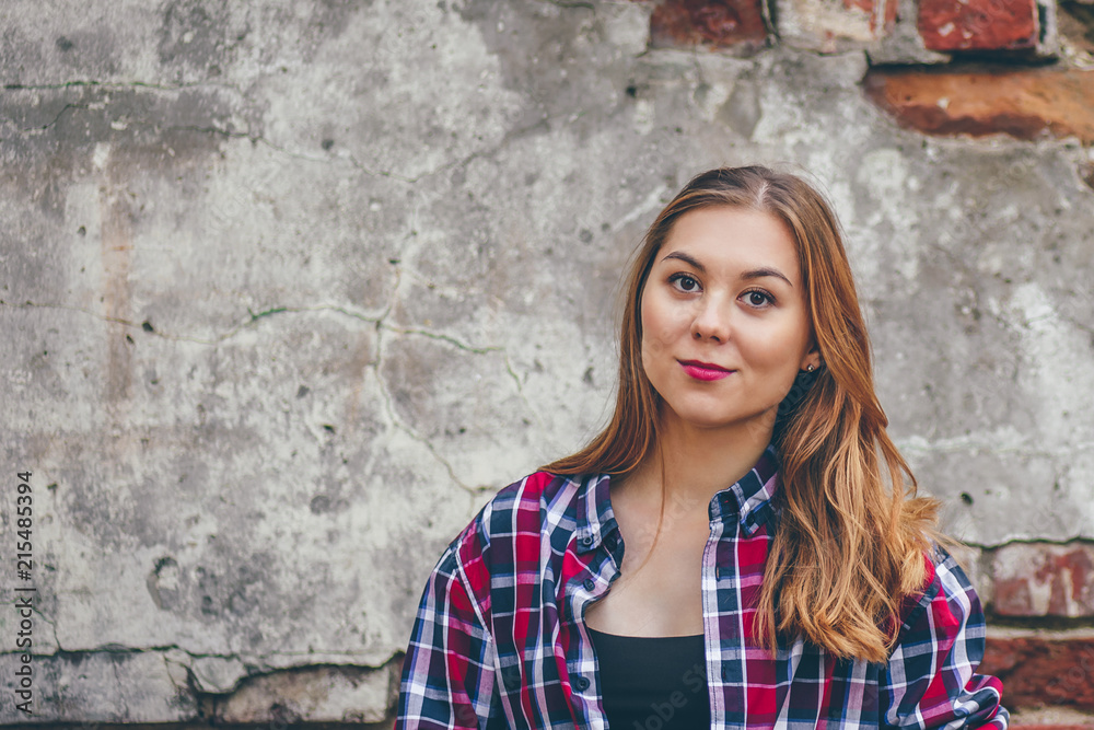 Beautiful girl is standing against brick wall Beautiful girl is standing against brick wall