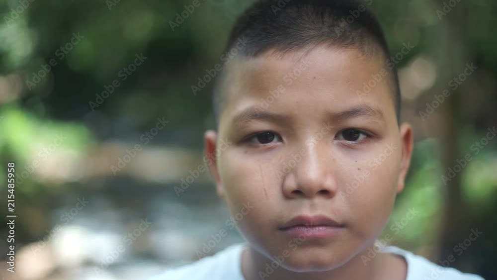 Sad young Asian boy sitting alone Sad young Asian boy sitting alone