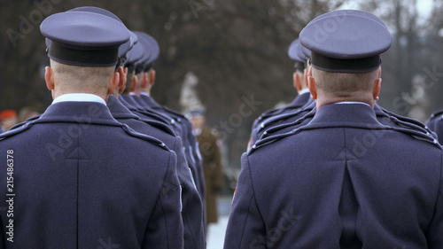 the commander gives awards to soldiers in blue uniform, soldiers stand with their backs