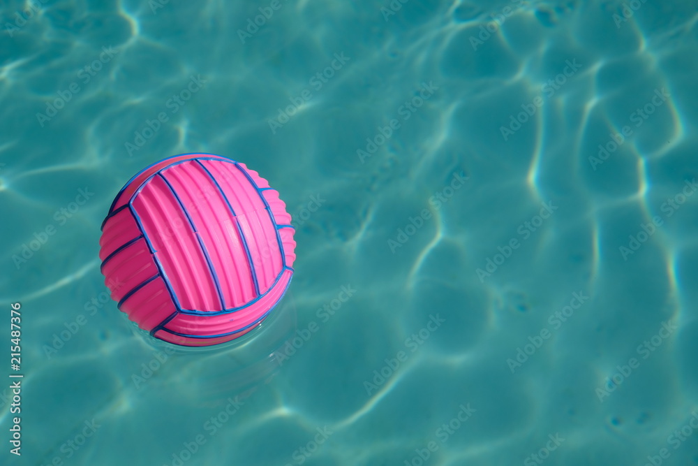 Pink ball with blue stripes on a blue water surface