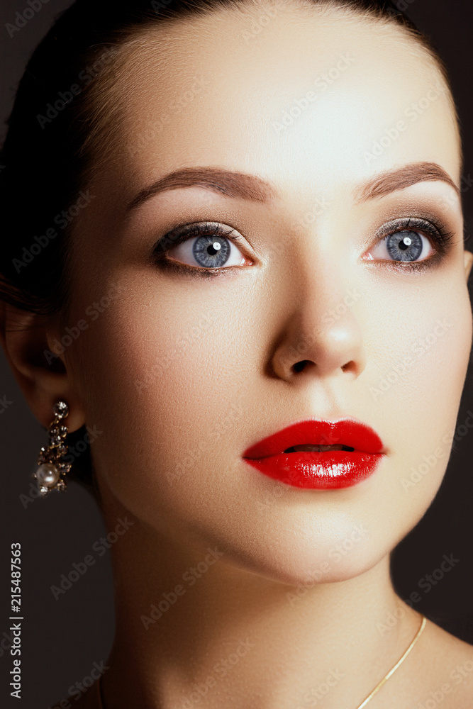 Beauty Brunette Woman with Perfect Makeup. Beautiful Professional Holiday Make-up. Red Lips, perfect eyebrows. Beauty Girl's Face. Gold earrings with pearls and diamonds Beauty Brunette Woman with Perfect Makeup. Beautiful Professional Holiday Make-up. Red Lips, perfect eyebrows. Beauty Girl's Face. Gold earrings with pearls and diamonds