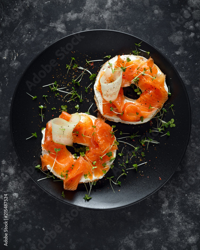 Billede på lærred Smoked salmon bagel toasts with soft cheese, cucumber ribbons and cress salad