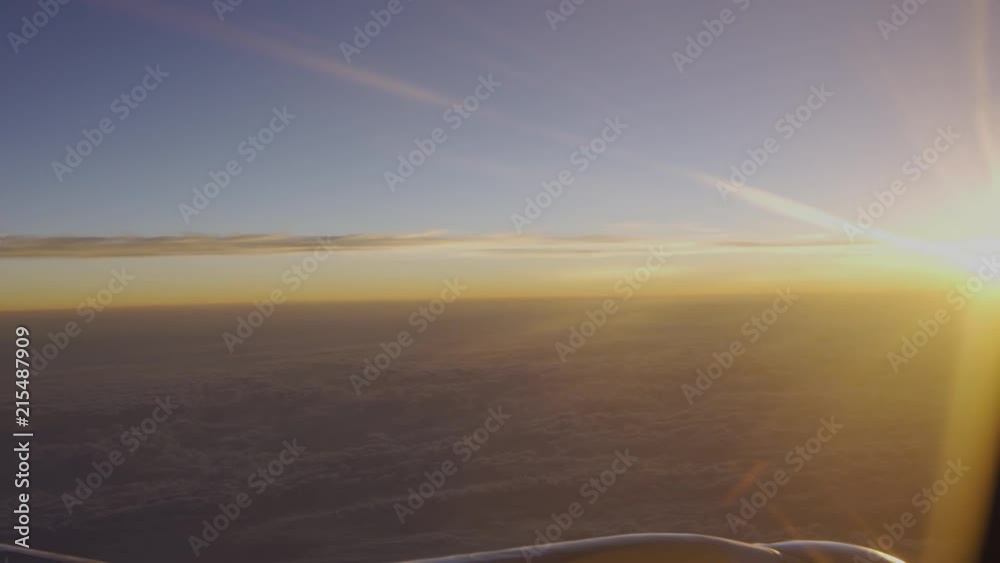 Orange sunrise seen from the sky while in airplane coming in from a red eye flight