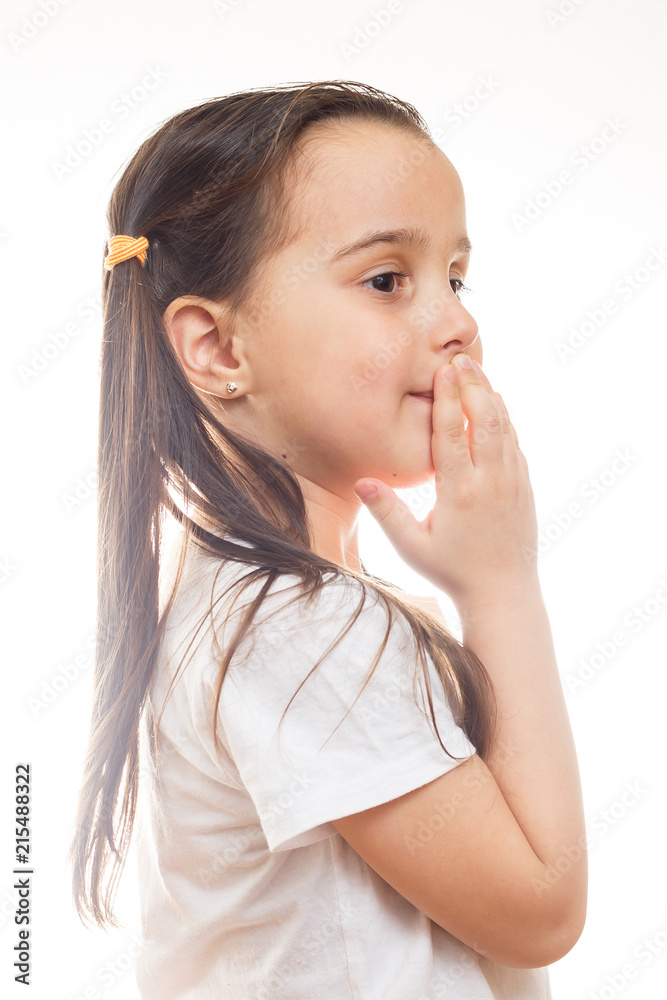 Positive little girl in casual white t shirt indicates at blank space for logo design Positive little girl in casual white t shirt indicates at blank space for logo design