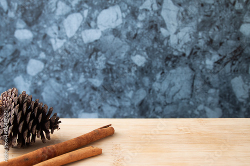 Cinnamon sticks and pine cone on wooden table, Autumn concept, Space for product