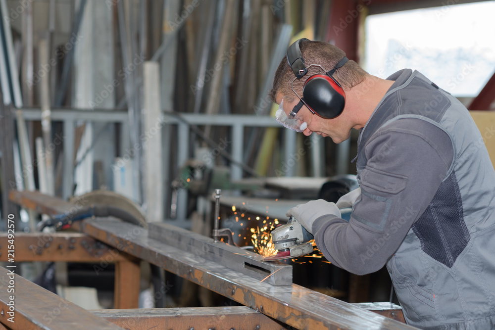 Man angle grinding metal