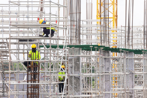 asian construction workers working on scaffolding of building construction site. urban expansion in capital city of asia are growing fastest with real estate investment and economic growth.