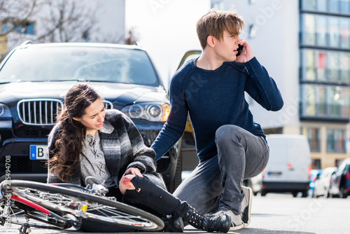 Fotografie Young man looking for the ambulance while calling the emergency services after h
