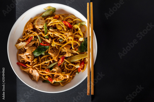 wok stir-fry egg noodles with fried chicken and thai spices and, traditional spicy asian cuisine food photo