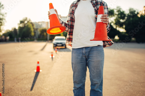 Male vehicle instructor holds cones in hands