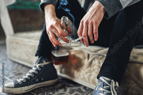 Photos Addicted male person with cigarette and alcohol