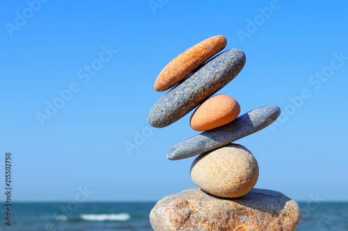 Unstable construction of multi-colored stones. The disturbed equilibrium. Imbalance concept photo