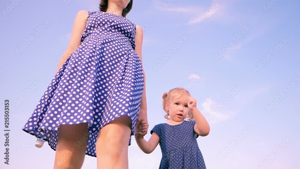 Girls are walking in blue dress. Slow motion video. Bottom angle shot