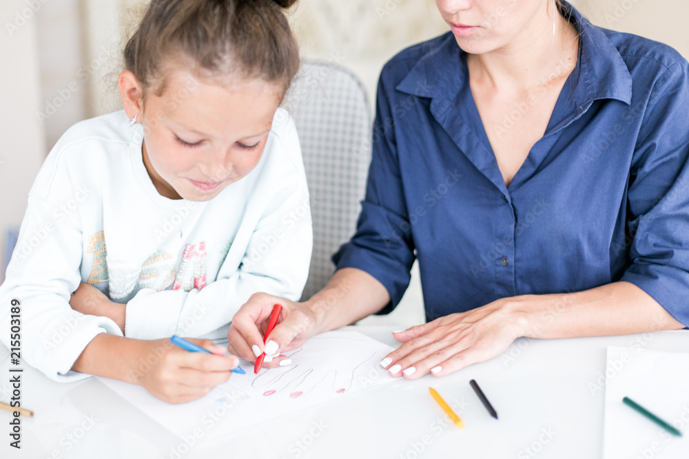 Happy family. Mother and daughter together paint and draw. Adult woman helps the child girl Happy family. Mother and daughter together paint and draw. Adult woman helps the child girl