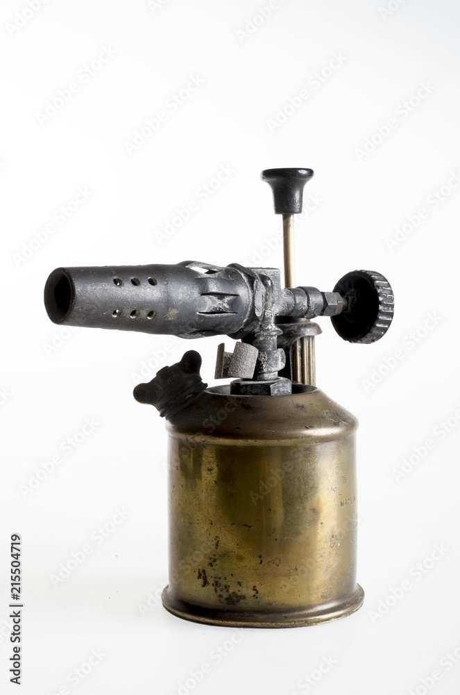 Antique blowtorch in a plain background