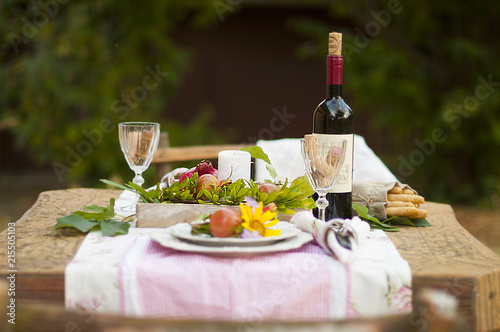 Lunch in the garden with wine and fruit. Romantic dinner in the open air. Autumn leaves of flowers. Beautiful table scrapbooking. Vintage photo