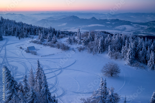 Szlaki skuterów śnieżnych o wschodzie słońca photo