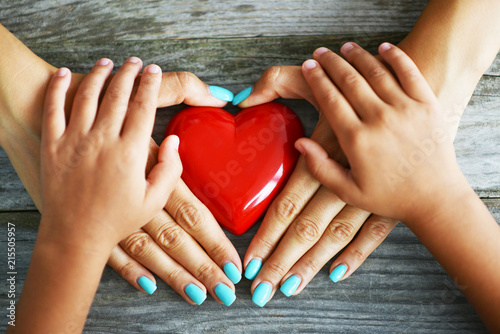 Foto Mother and child pure love concept, with red hearth in their hands on rustic woo