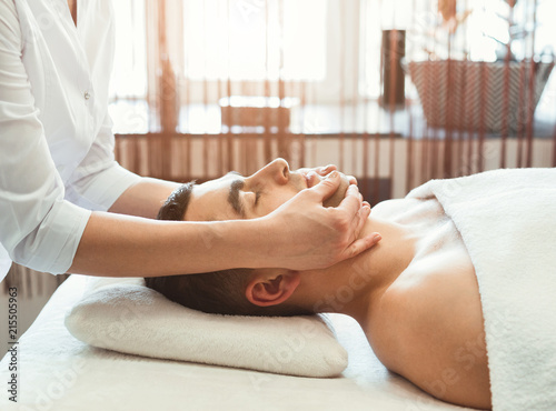 Handsome man getting professional facial massage