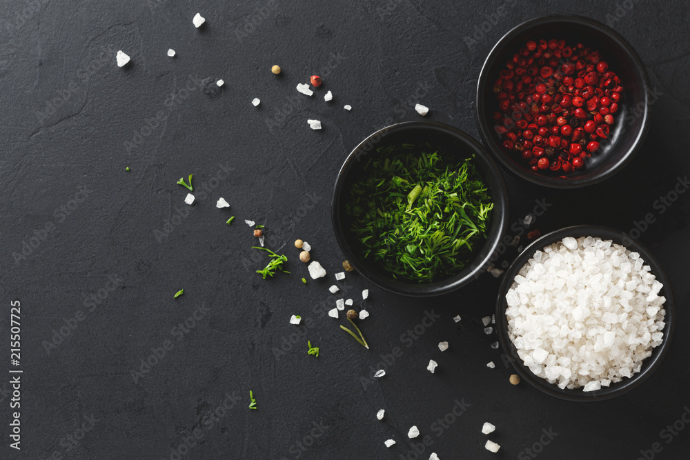 Diverse spices in plates on black background