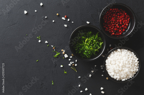 Diverse spices in plates on black background