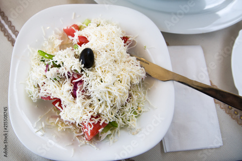 фотографія Bulgarian, serbian and macedonian traditional cuisine Shopsky salad or shopska salata with tomatoes, cucumbers, paprika, onion and goat cheese brynza