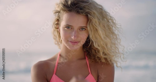 portrait of young sexy blonde woman smiling playful enjoying warm summer day on sunny beach wearing bikini confident flirty female real people series