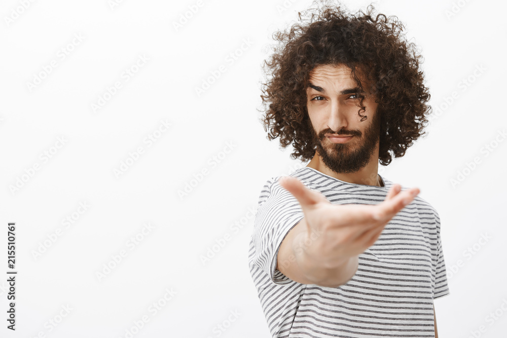 Portrait of handsome confident macho man with beard and curly hair, pulling hand towards camera as if intoducing girlfriend to dance, flirting and making positive impression on attractive woman Portrait of handsome confident macho man with beard and curly hair, pulling hand towards camera as if intoducing girlfriend to dance, flirting and making positive impression on attractive woman