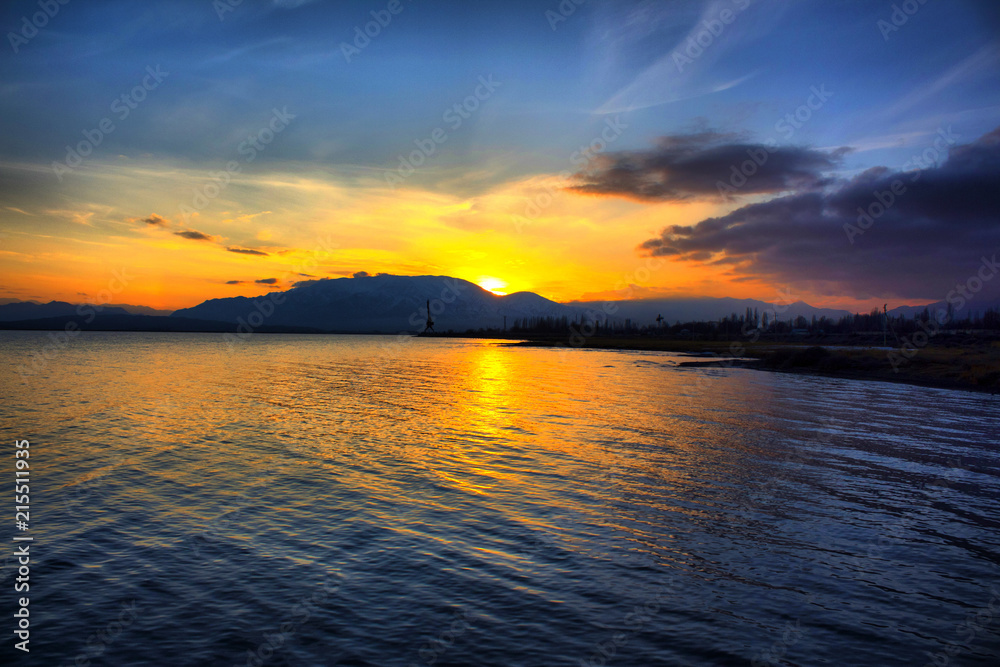 Naklejka premium Sunset over the mountains near the lake