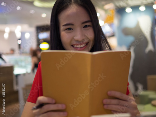 Young Asian female student with notebooks in her hands.A portrait of an Asian college student.education and learning concept.