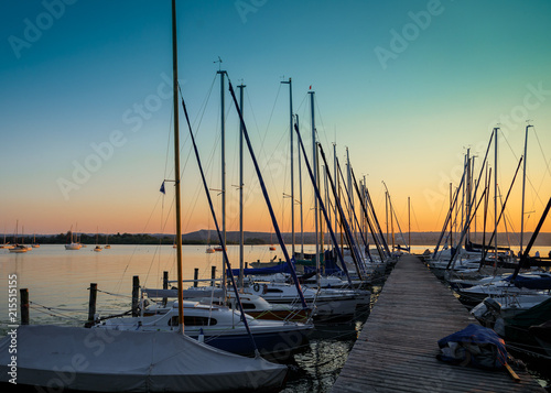 Fototapeta Naklejka Na Ścianę i Meble -  Segelboote am Bootssteg am Ammersee in der Abendsonne