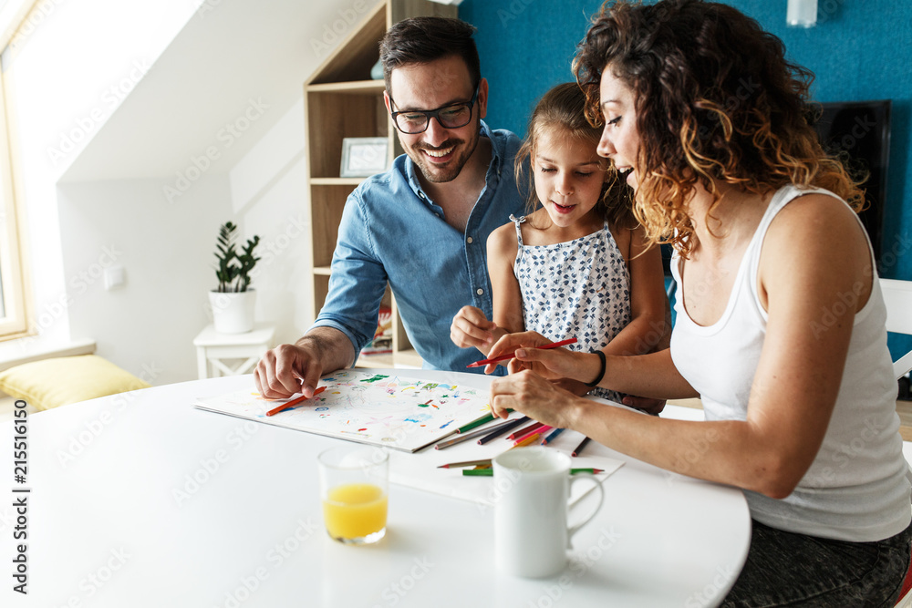 Parents teach they young daughter to draw.They sitting in living room and draws with colored pencils. Parents teach they young daughter to draw.They sitting in living room and draws with colored pencils.