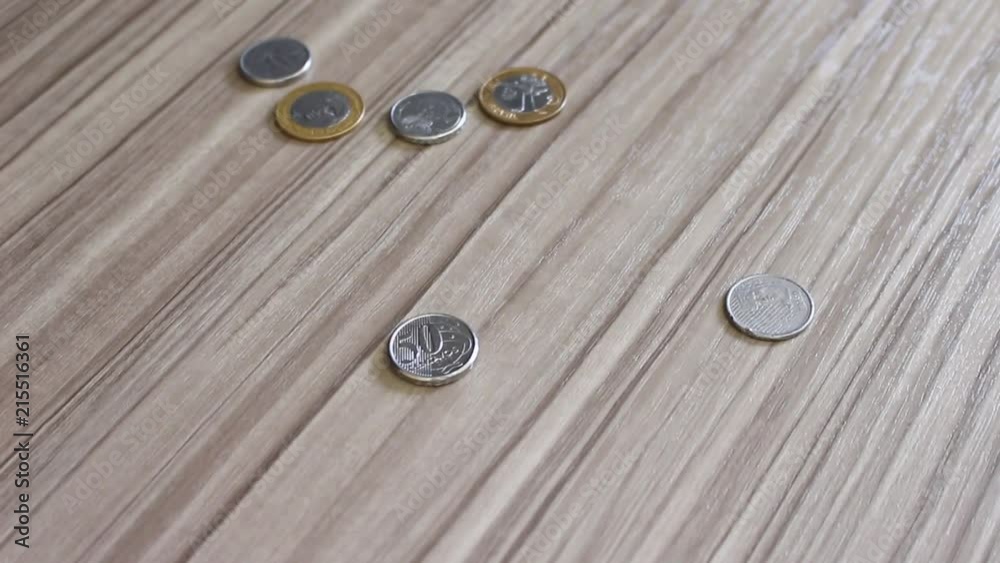 Moedas em real do Brasil caindo na mesa