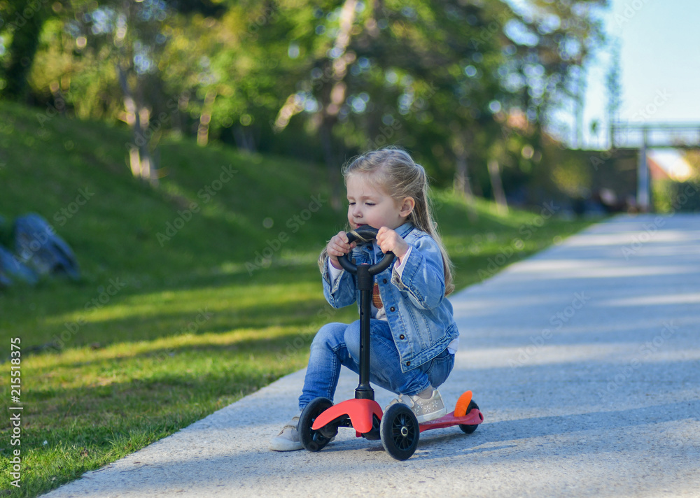 Little girl is riding a scooter Little girl is riding a scooter