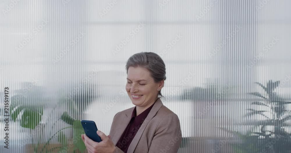 portrait successful mature business woman boss using smartphone enjoying browsing online messages texting on mobile phone smiling satisfaction slow motion portrait successful mature business woman boss using smartphone enjoying browsing online messages texting on mobile phone smiling satisfaction slow motion