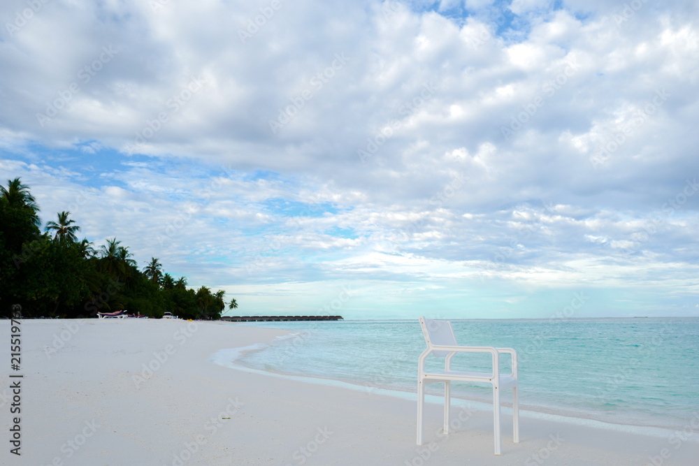 Summer concept , White chair on the beach white sand and turquoise sea color at maldives on the weekend holidays Summer concept , White chair on the beach white sand and turquoise sea color at maldives on the weekend holidays