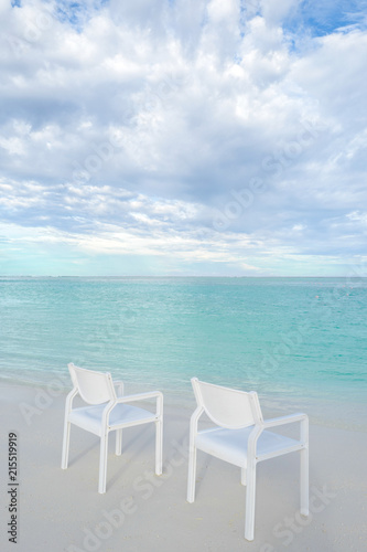 Fototapeta Naklejka Na Ścianę i Meble -  Summer concept , White chair on the beach white sand and turquoise sea color at maldives on the weekend holidays