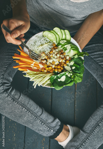 woman having Healthy breakfast, raw vegan food in Buddha Bowl photo