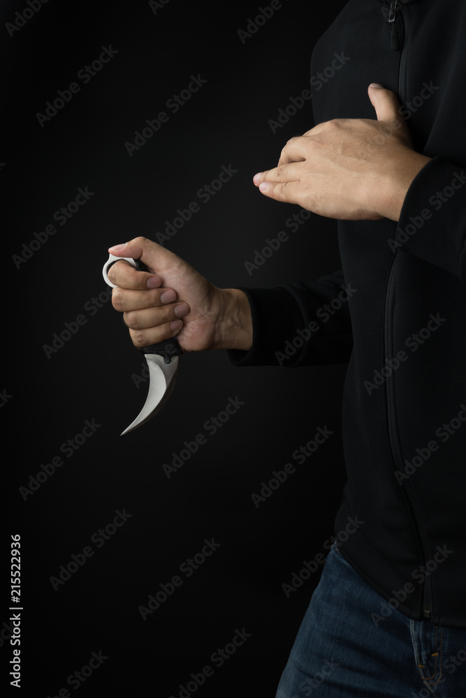 Crime and violence concept, a murderer with a karambit knife trying to kill victim