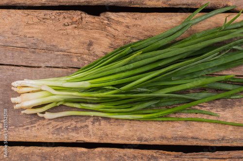 Bunch of green onion. Old rustic wooden table background.