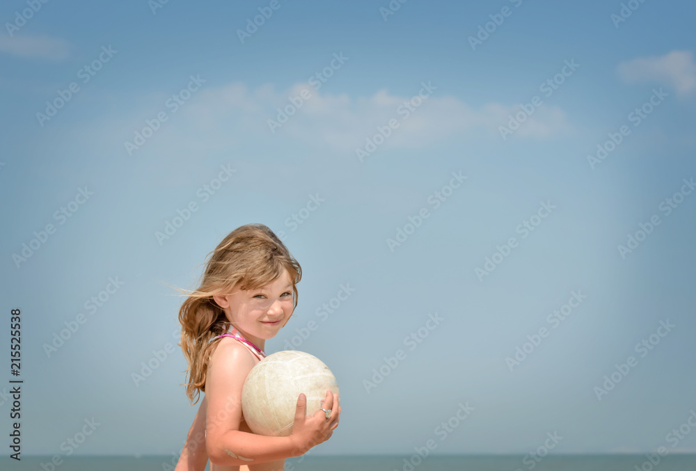 adorable enfant jouant au ballon sur la plage Photos