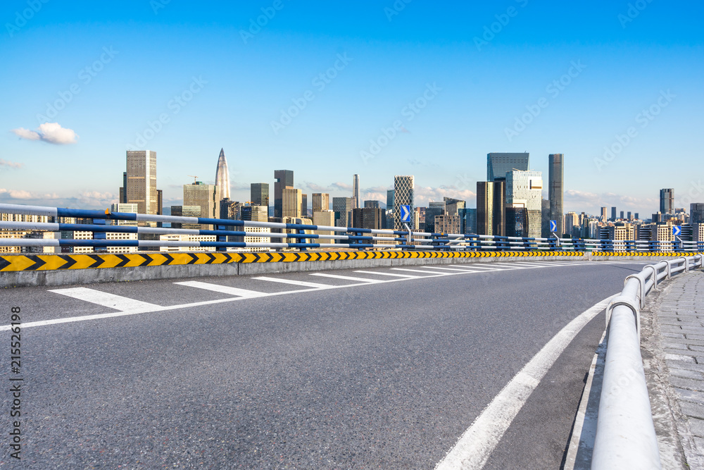 asphalt road with city skyline