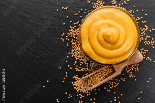 mustard in a bowl on a rustic background photo