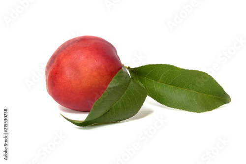 Nectarine with green leaves isolated on white background
