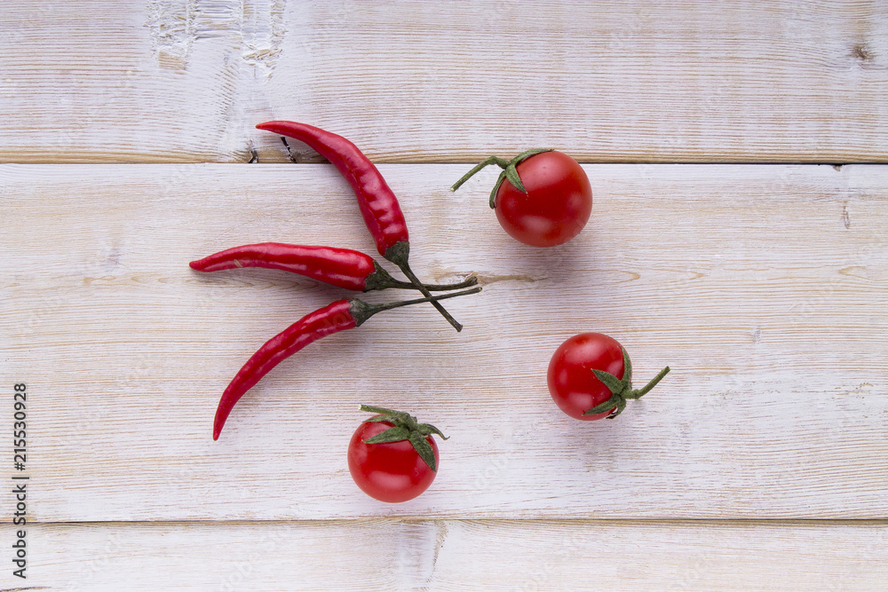 Red pepper tomatoes garlic parsley on a white wooden background. Red pepper tomatoes garlic parsley on a white wooden background.
