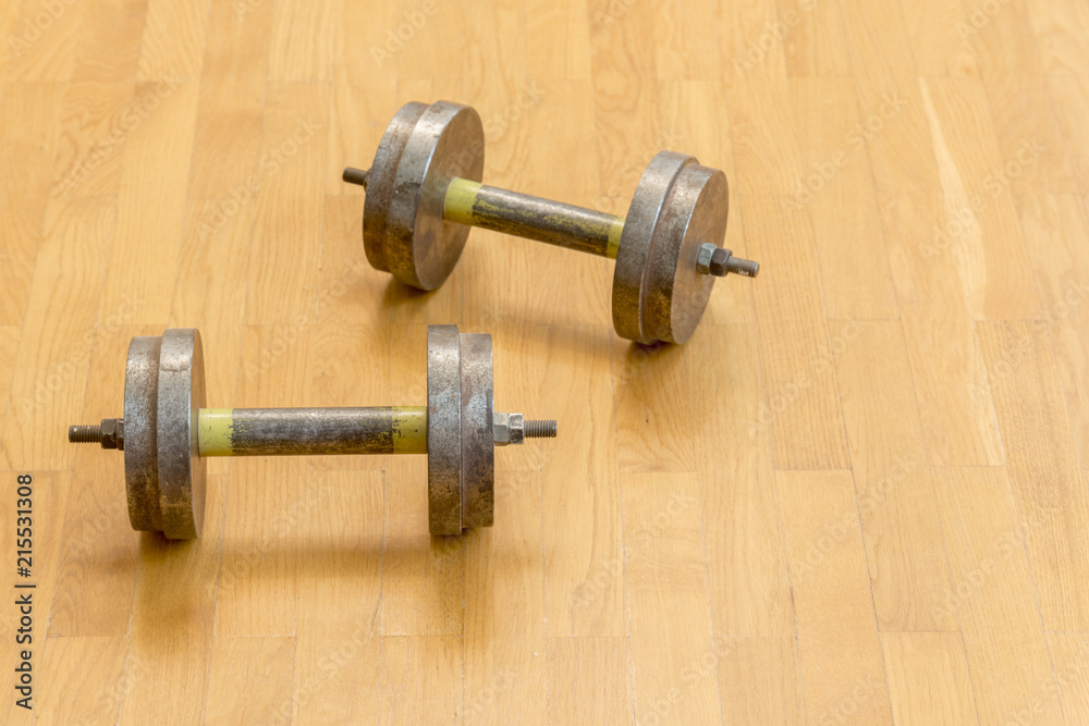 Two iron dumbbells on the floor. the concept of a healthy lifestyle and sport Two iron dumbbells on the floor. the concept of a healthy lifestyle and sport